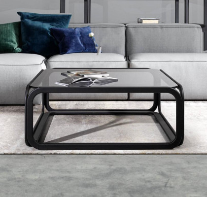 Rectangular coffee table made of glass with modern wooden frame in living room