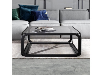 Rectangular coffee table made of glass with modern wooden frame in living room