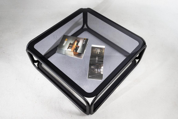 Rectangular coffee table made of glass with modern wooden frame in living room