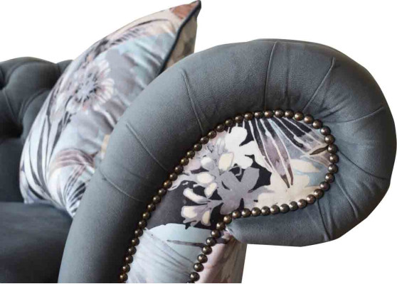 A striking three-seater sofa in a Chesterfield design with delicate gray floral decoration