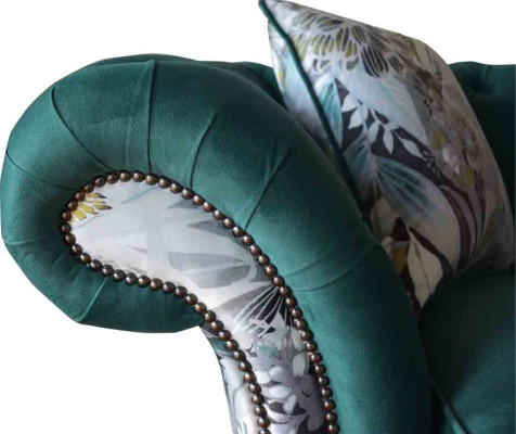 A vibrant three-seater Chesterfield sofa in a delicate emerald color with a floral pattern